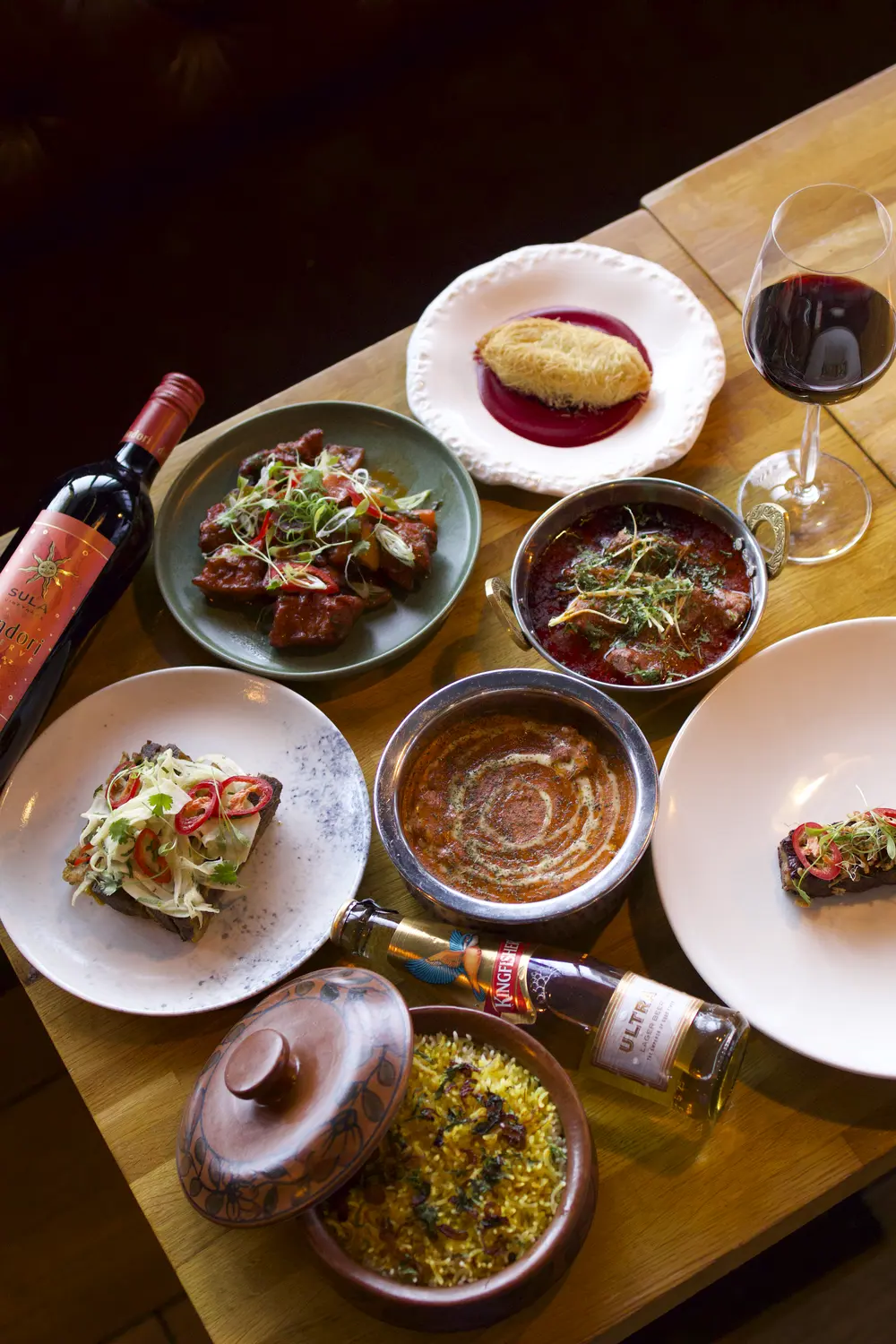 A shared Indian feast laid across a private dining table